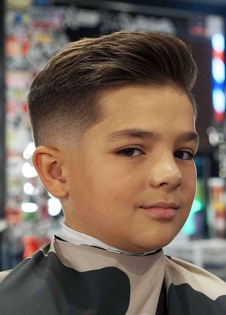 Teenage redhead boy haircuts hairdresser in the Barber shop. Fashionable  stylish retro hairstyle. Portrait of a child with a beautiful haircut.  Russia Stock Photo - Alamy